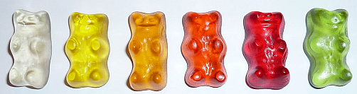 a row of six gummy bears in different colours: translucent, yellow, orange, bright red, dark red and green